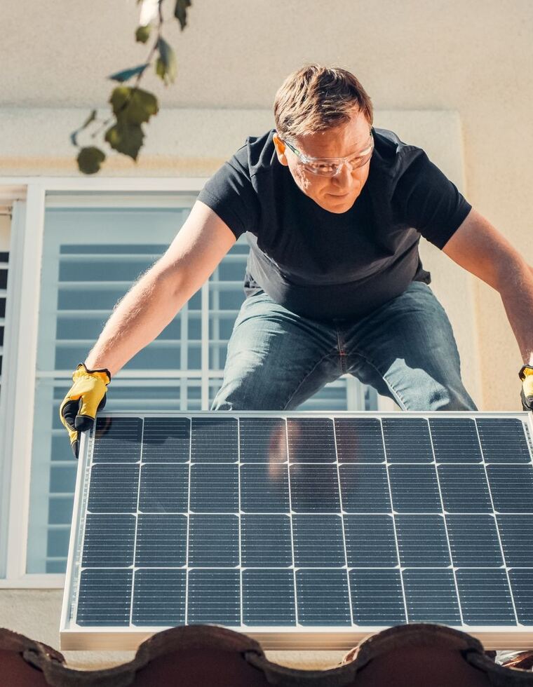 Tecnico installa un pannello fotovoltaico sul tetto di un'abitazione